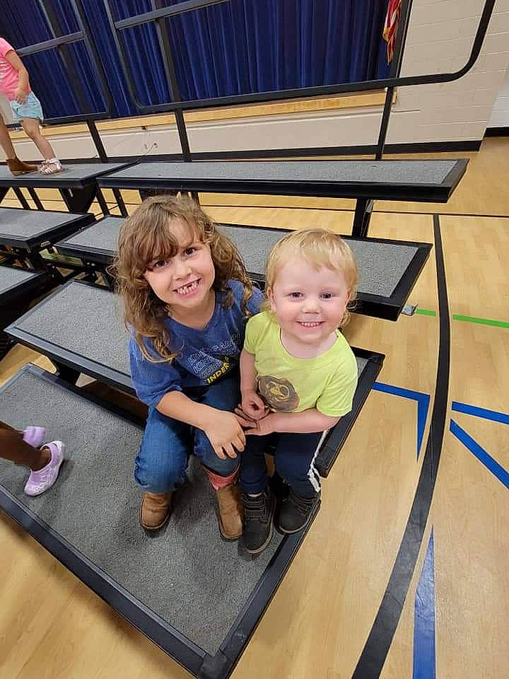 Raven is registered to the contest to win money with this photo: chair, child, event, facial_expression, floor, flooring, fun, happy, joy, leisure, motor_vehicle, person, play, recreation, sitting, smile, t_shirt, toddler, travel, vacation