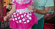Brianna is registered to the contest to win money with this photo: barefoot, bow, casual, child, clothing, costume, decor, furniture, holding_hands, home, indoor, minnie_mouse, person, pink_dress, supporting, table, toddler, toy, water_bottle, woman
