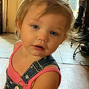 Brianna joined the competition — help win amazing prizes! child, toddler, indoor, denim_overalls, pink_clothing, blue_eyes, curly_hair, face, portrait, floor, furniture, wooden, tile_floor, person, cute, looking, young_child, casual_clothing, closeup, baby