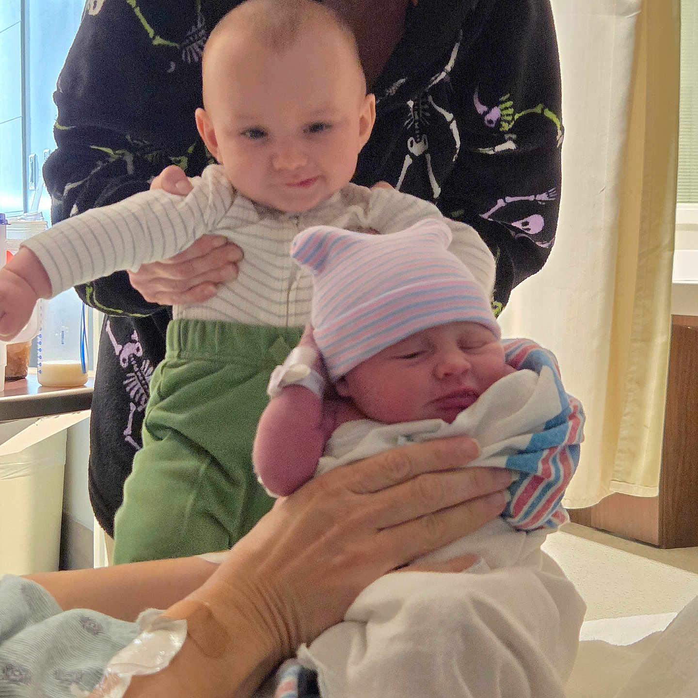 Richard joined the competition — help win amazing prizes! adult, baby, bed, blanket, clothing, curtains, family, green_pants, hand, hat, holding, hospital, indoor, infant, medical, newborn, person, smile, striped, wristband