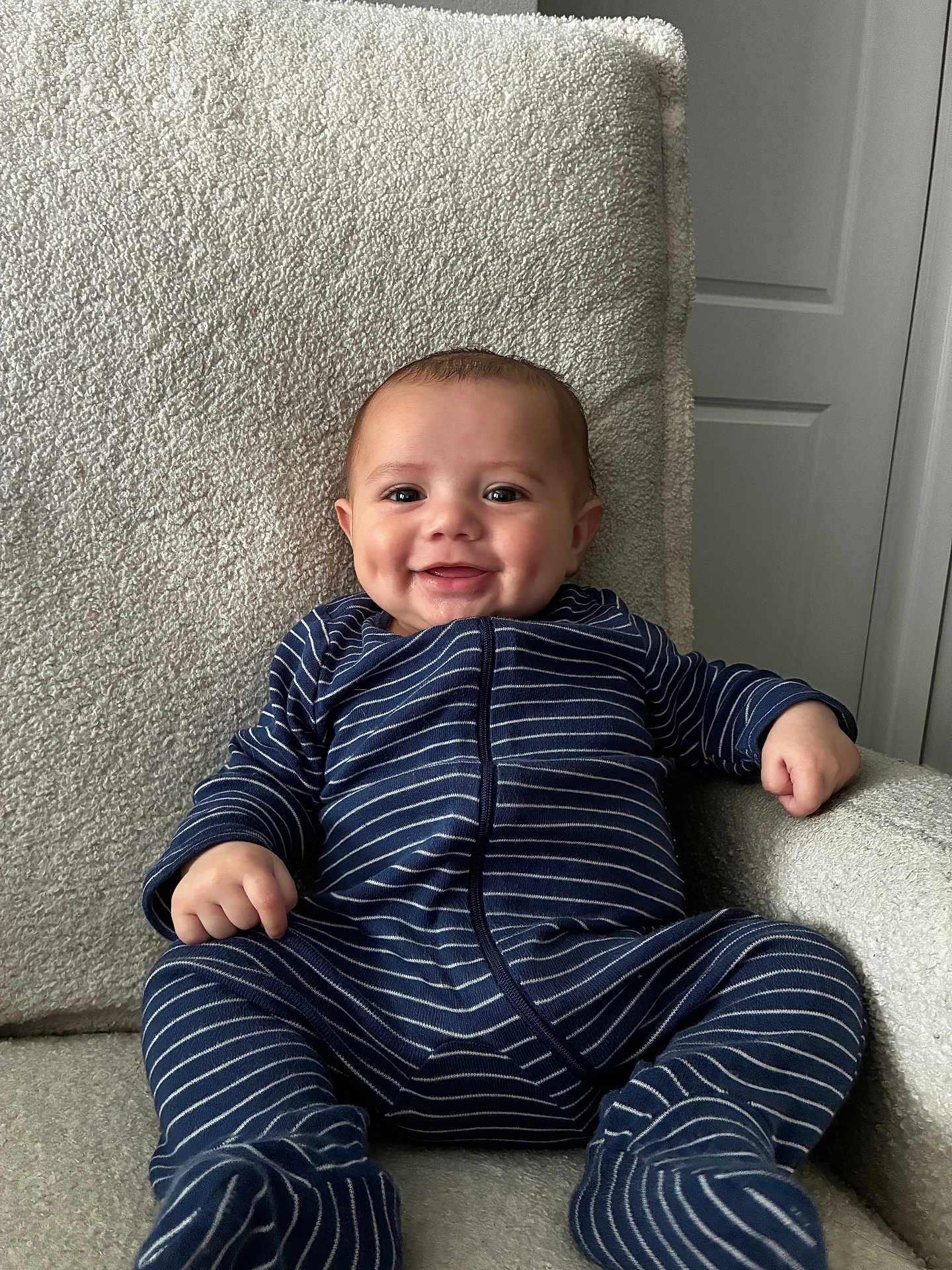Kaleio joined the competition — help win amazing prizes! baby, infant, smiling, onesie, striped_clothing, armchair, indoor, happy, dimple, child, furniture, seated, cute, portrait, person, cozy, relaxed, soft_texture, home, young_child
