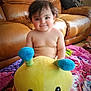 baby, child, plush_toy, stuffed_animal, smile, indoor, living_room, couch, blanket, cute, person, toddler, toy, colorful, happy, furniture, soft_toy, floor, hair, skin