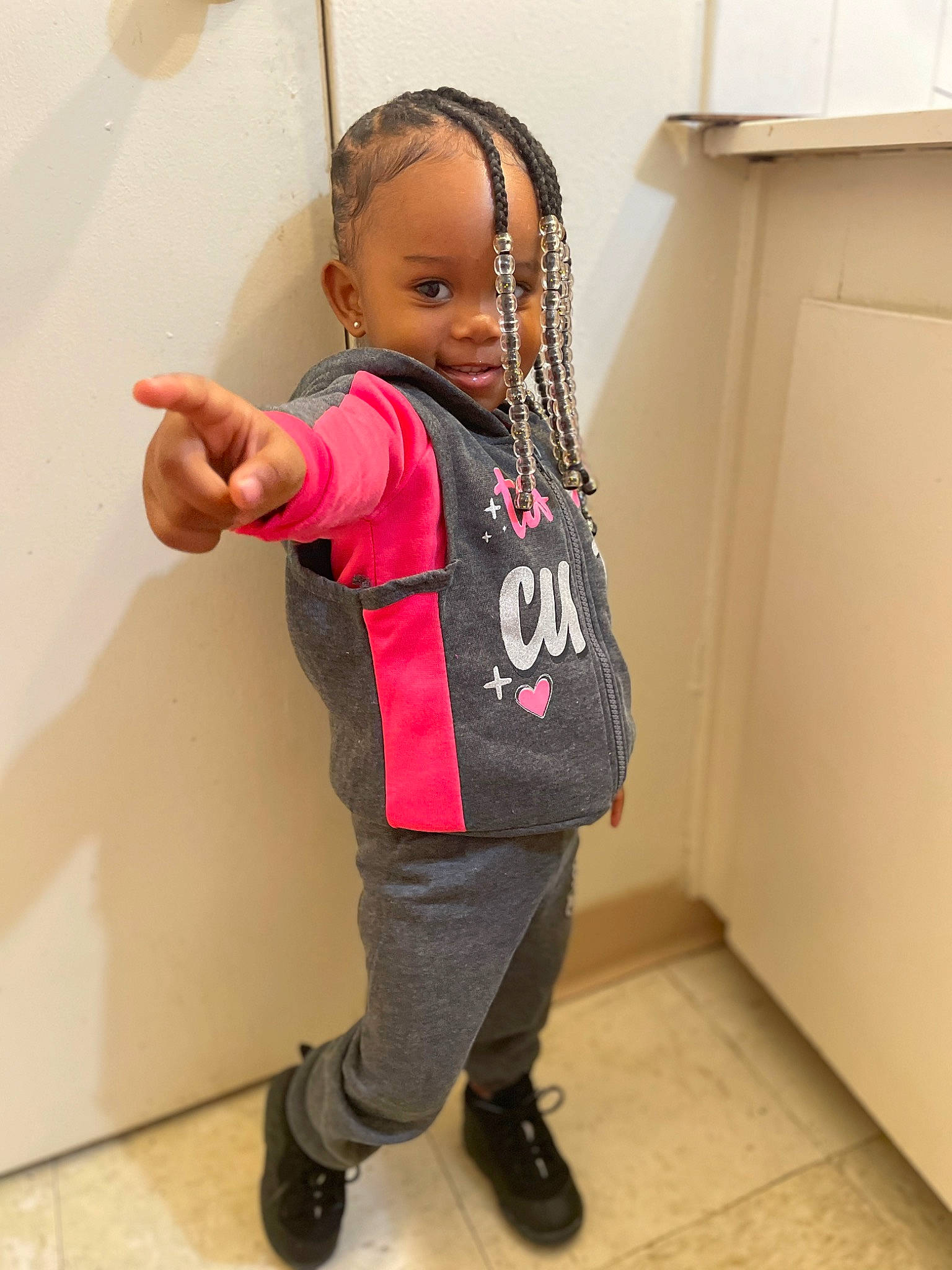 Kenslee is registered to the contest to win money with this photo: baby, baby_toddler_clothing, bag, carmine, cheek, child, fashion_accessory, flooring, fun, gesture, happy, joint, luggage_and_bags, magenta, person, room, sleeve, standing, t_shirt, toddler