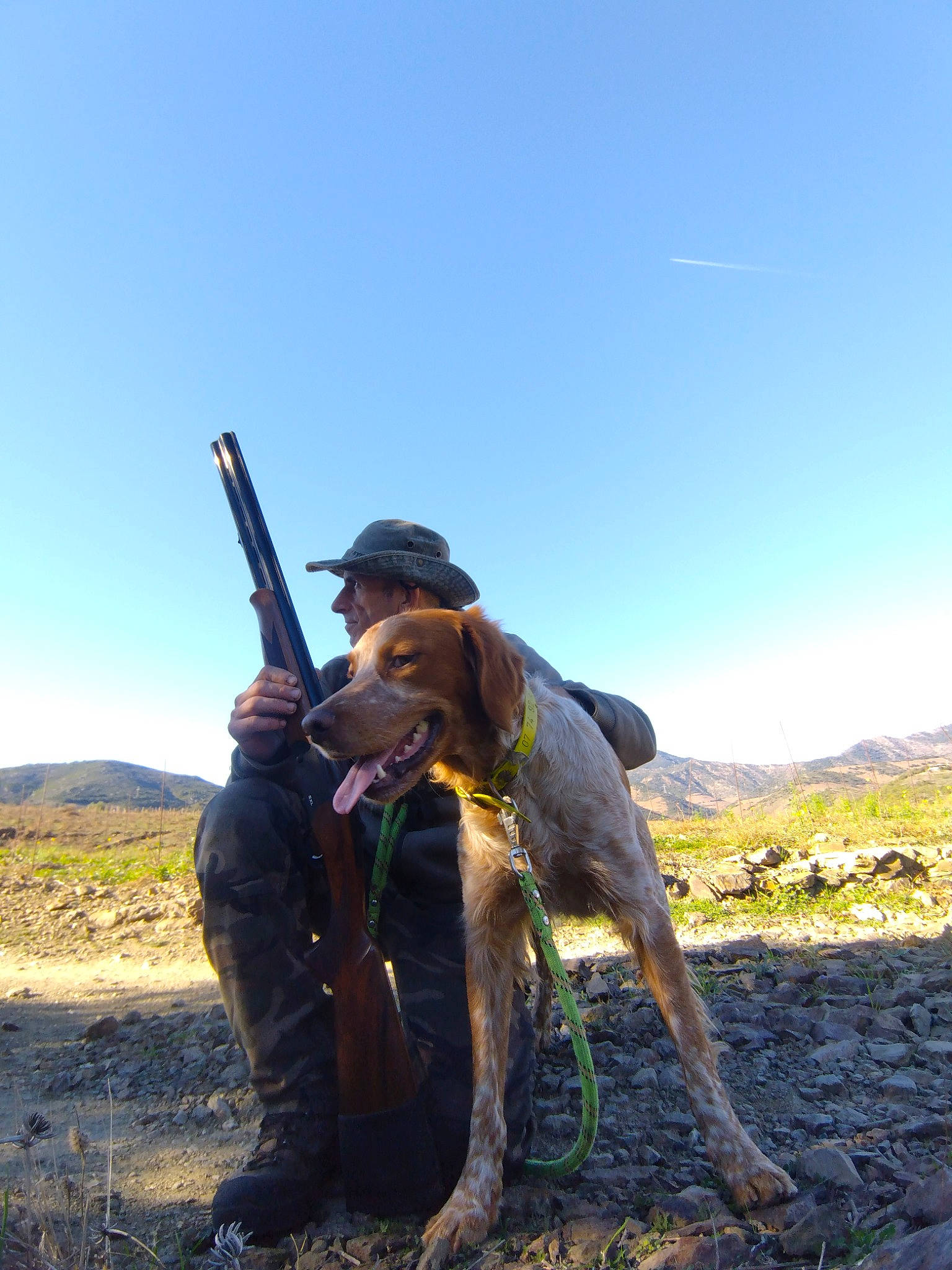 Toc participe au concours pour gagner de l'argent avec cette photo : air_gun, carnivore, dog, dog_breed, fun, grass, grassland, gun_barrel, hat, landscape, mountain, outdoor_recreation, people_in_nature, plant, plant_community, recreation, shooting, shotgun, sky, soil