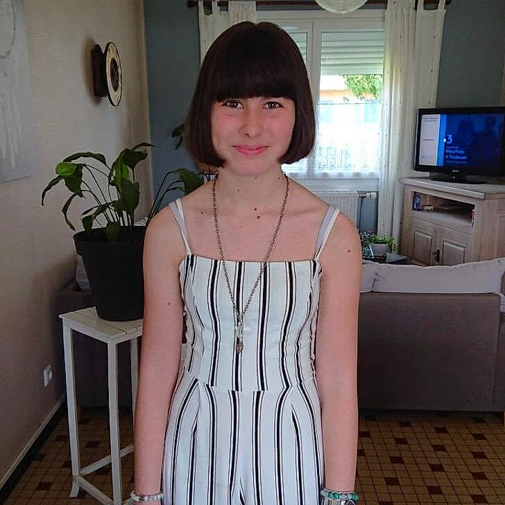 Sarah participe au concours pour gagner de l'argent avec cette photo : black_hair, day_dress, display_device, dress, entertainment_center, fashion_design, flowerpot, home_appliance, houseplant, human_leg, joy, neck, person, plant, room, shoulder, sleeve, television, television_set, thigh