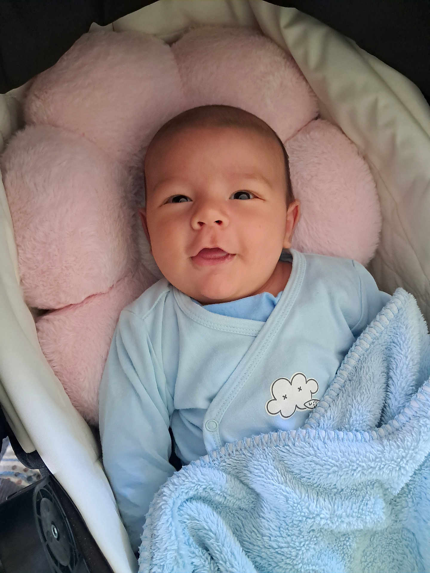 Augustin participe au concours pour gagner de l'argent avec cette photo : baby, infant, blanket, blue_clothing, pink_cushion, face, smiling, lying_down, cozy, soft_texture, indoor, child, cute, newborn, portrait, comfortable, wrapped, resting, head, person
