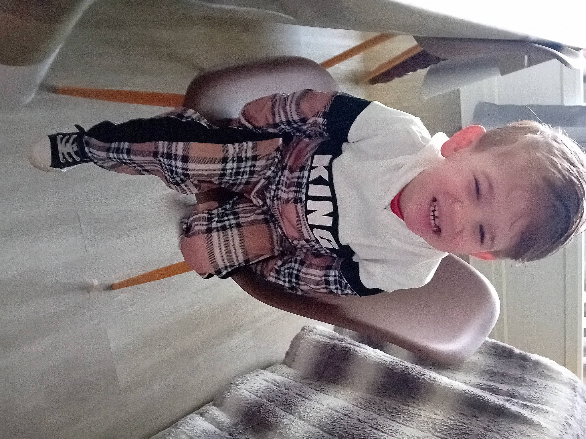 Axel participe au concours pour gagner de l'argent avec cette photo : baby, baby_toddler_clothing, child, comfort, elbow, eyewear, flash_photography, flooring, happy, human_leg, joy, pattern, person, plaid, sitting, sleeve, smile, tartan, thigh, toddler