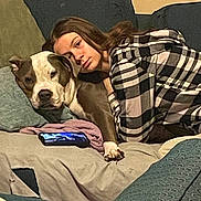Garnet joined the competition — help win amazing prizes! blanket, brown_dog, casual, checkered_shirt, comfort, companion, couch, dog, furniture, home, indoor, living_room, paw, person, phone, plaid_clothing, relaxing, resting, snuggling, white_dog