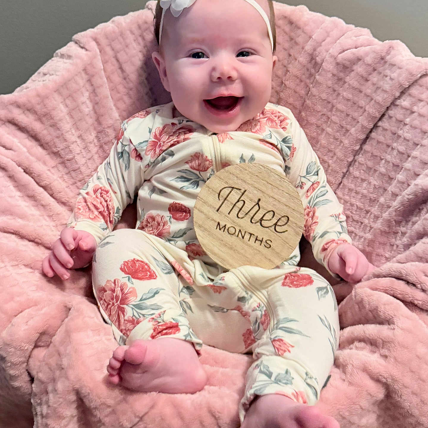 Oakley joined the competition — help win amazing prizes! baby, child, cute, face, feet, floral_onesie, flower, hands, happy, headband, indoor, infant, pink_blanket, portrait, sitting, smiling, soft_texture, three_months, wooden_sign, young