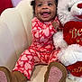 Reign joined the competition — help win amazing prizes! baby, child, smiling, pajamas, boots, teddy_bear, stuffed_animal, heart_pattern, chair, indoor, cute, joyful, happy, infant, person, portrait, love, plush, seated, cozy