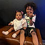 Reign is registered to the contest to win money with this photo: child, baby, sitting, bench, smiling, curly_hair, pink_bows, socks, marvel, tshirt, shorts, leather_bench, indoor, wall, floor, happy, family, portrait, two_children, playful