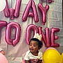 baby, birthday, cake, balloon, crown, celebration, pink, yellow, blue_frosting, heart_shaped_cake, party, child, sitting, cute, happy, indoor, decorations, first_birthday, smiling, festive