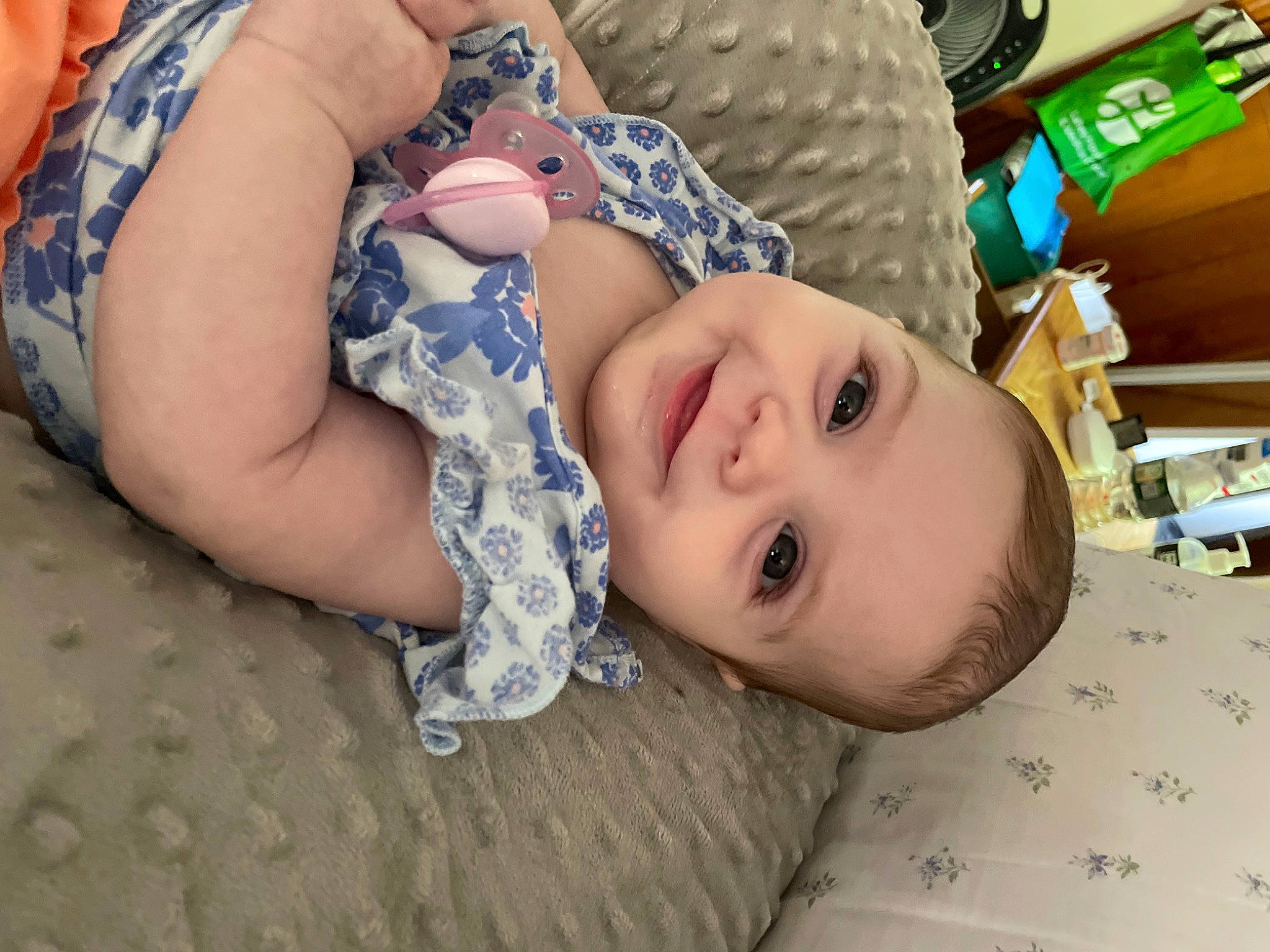 Fiona is registered to the contest to win money with this photo: baby, child, comfort, cool, flooring, fun, grass, happy, joy, linens, mouth, nose, pattern, person, sitting, skin, smile, textile, thigh, toddler