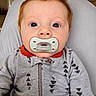 baby, pacifier, red_hair, onesie, gray_clothing, indoor, child, face, portrait, young_child, sitting, cozy, cute, head, expression, patterned_clothing, infant, person, closeup, casual