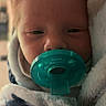 Emry is registered to the contest to win money with this photo: baby, newborn, pacifier, blanket, closeup, face, sleepy, infant, wrapped, cozy, soft, cute, child, person, indoors, pacifier_teal, warm, comfort, head, portrait