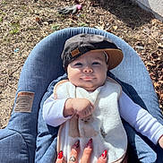 Liam a rejoint le concours — aidez-le/la à gagner de superbes lots ! baby, child, cap, hat, bib, hand, nail_art, tattoo, outdoor, seat, blue, clothing, face, person, infant, cute, smile, sunlight, nature, relaxing