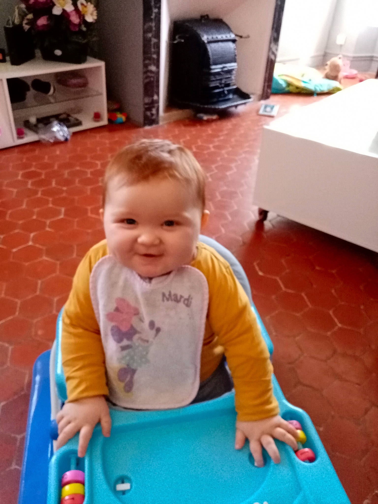 Analya a rejoint le concours — aidez-le/la à gagner de superbes lots ! baby, baby_products, baby_toddler_clothing, child, floor, flooring, fun, hardwood, home_appliance, kitchen_appliance, leisure, person, play, room, shelf, sitting, smile, television, toddler, white