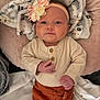 Cova is registered to the contest to win money with this photo: baby, infant, headband, flower, blanket, cozy, clothing, buttons, pants, cute, portrait, indoor, soft_lighting, baby_girl, lying_down, pink, cream, rust_color, child, newborn