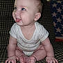 Mylo is registered to the contest to win money with this photo: baby, child, tongue, drool, blue_eyes, sitting, couch, checkered_pattern, clothing, onesie, hands, feet, skin, indoor, cute, playful, portrait, infant, smiling, person