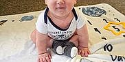 Mylo joined the competition — help win amazing prizes! baby, child, infant, blanket, carpet, floor, sitting, smiling, cute, indoors, person, young, clothing, socks, playful, curious, hands, face, head, expression