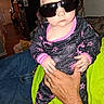 Salem is registered to the contest to win money with this photo: baby, child, infant, sunglasses, portrait, indoor, home, sitting, adult, hands, clothing, onesie, pink, black, stars, fashion, serious, funny, furniture, family