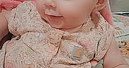 Salem joined the competition — help win amazing prizes! baby, infant, child, portrait, sitting, floral_outfit, pink_clothing, toy, colorful_toy, indoor, home, chair, pink_seat, face, eyes, bald_head, curious, cute, looking_away, cozy