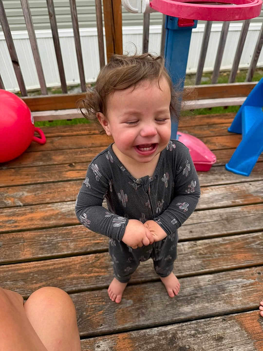 Evan joined the competition — help win amazing prizes! toddler, child, laughing, outdoor, deck, wooden_floor, playground, toy, red_ball, blue_slide, pajamas, curly_hair, barefoot, happy, smiling, person, wooden_railings, daylight, fun, cactus_pattern