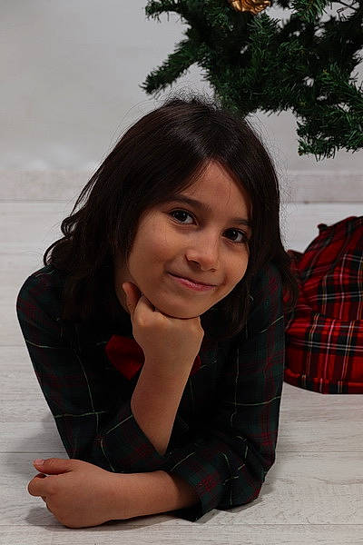 Francesco participe au concours pour gagner de l'argent avec cette photo : black_hair, brown_hair, evergreen, eye, facial_expression, flash_photography, fun, grass, hairstyle, happy, human_leg, joy, long_hair, person, plaid, plant, sitting, smile, tartan, thigh