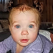 Amora is registered to the contest to win money with this photo: baby, child, blue_eyes, pigtails, curious, indoor, soft_lighting, face, person, infant, closeup, crawling, purple_clothing, home, carpet, expression, portrait, cute, young, skin