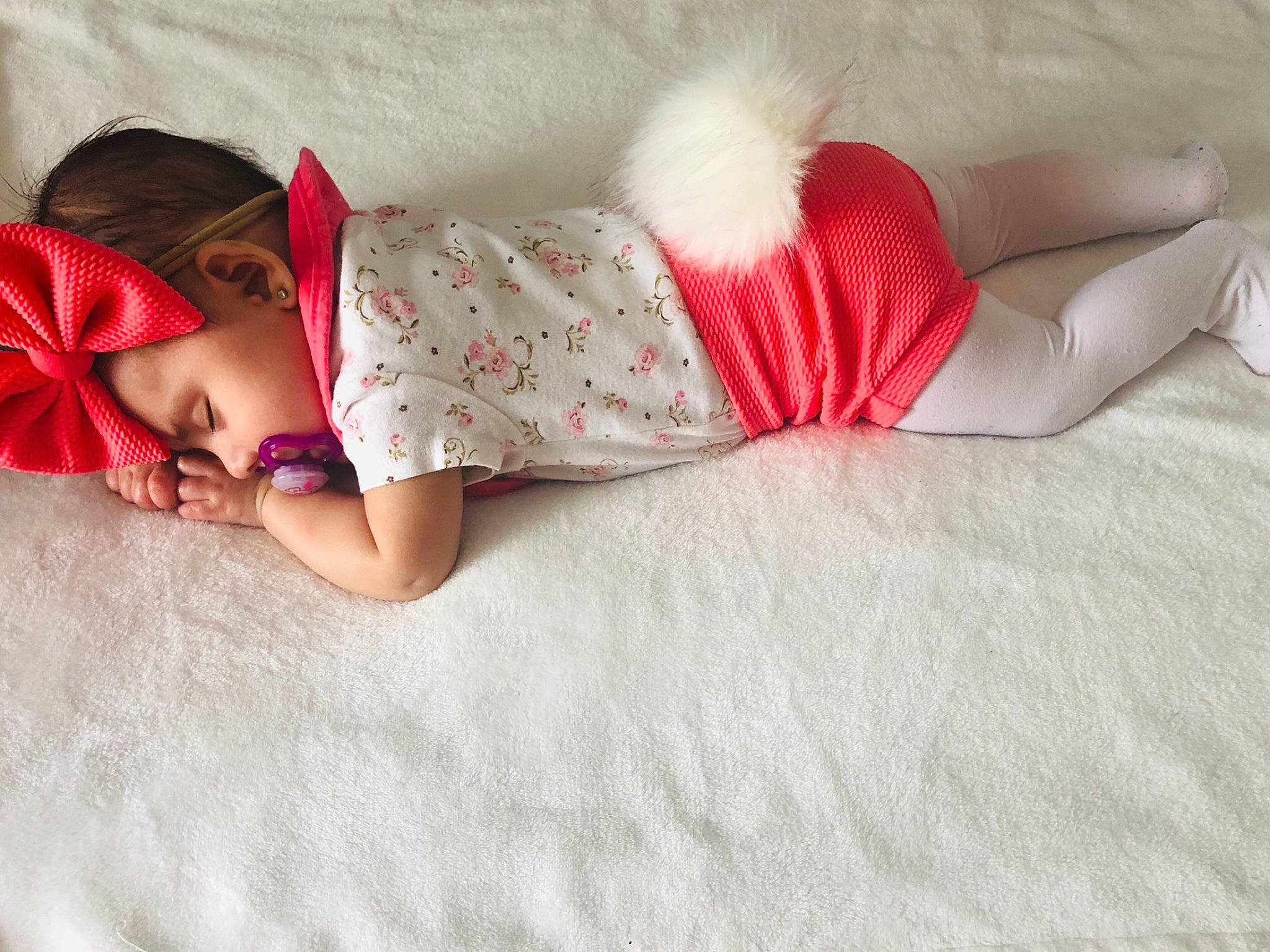 Victoria is registered to the contest to win money with this photo: arm, baby, baby_toddler_clothing, comfort, dress, eye, finger, foot, hand, headgear, human_body, human_leg, knee, leg, linens, magenta, pattern, person, skin, sleeve