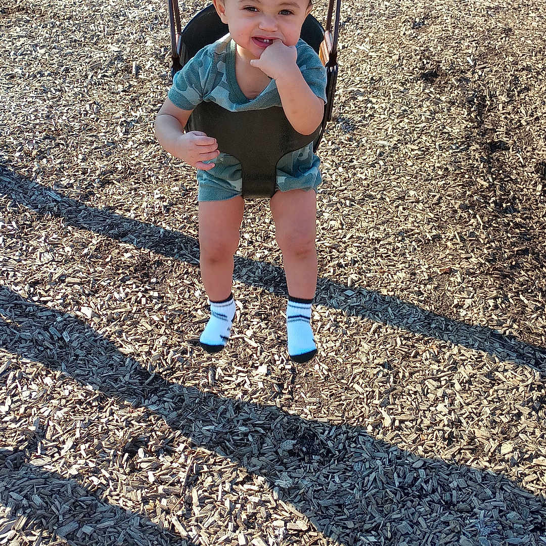 Tamarion is registered to the contest to win money with this photo: baby, clothing, face, footwear, grass, head, hosiery, nature, outdoorplayarea, outdoors, park, person, photography, plant, playarea, portrait, shorts, sock, soil, vegetation