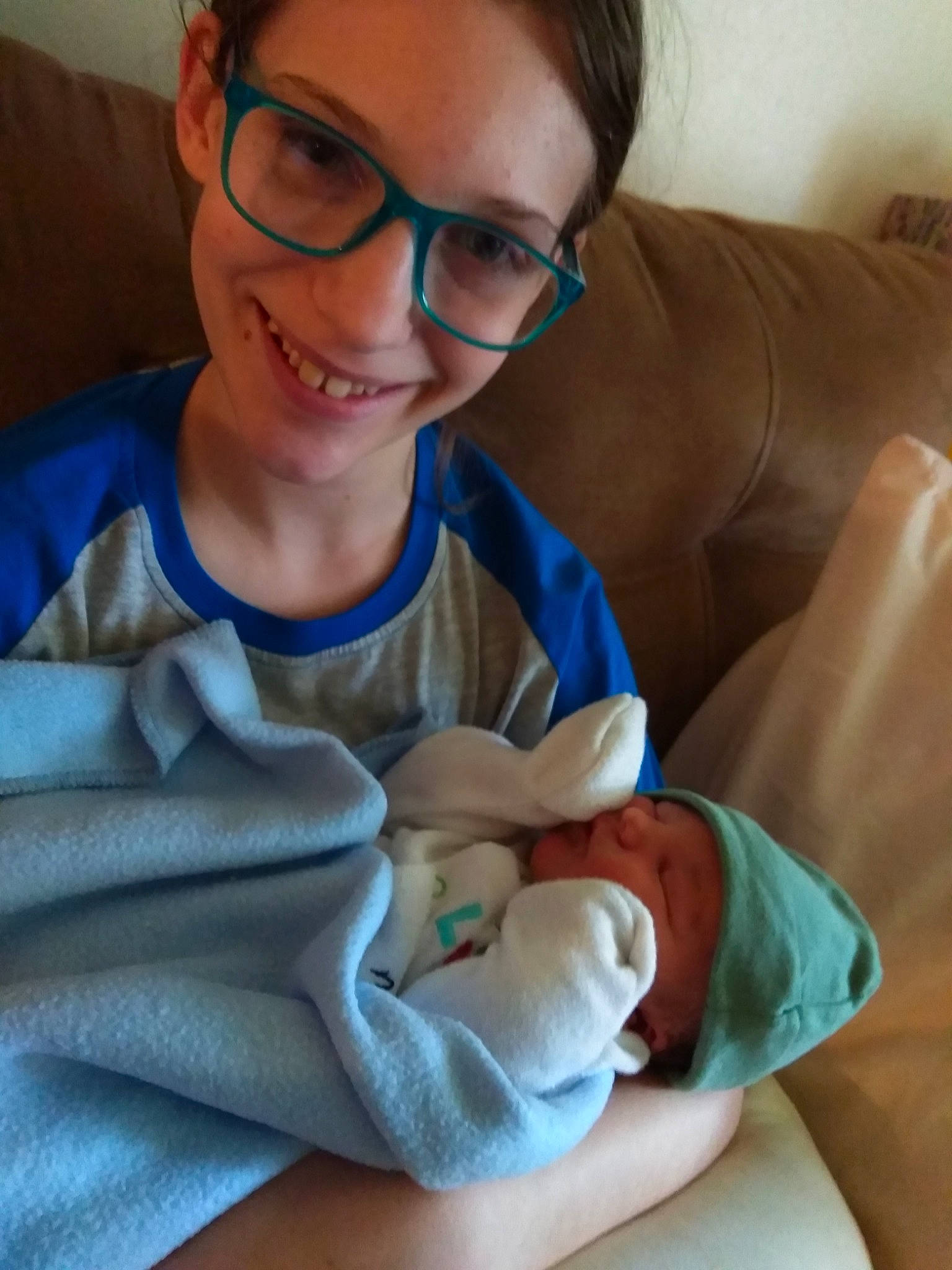 Jadyn is registered to the contest to win money with this photo: arm, baby, child, eyewear, glasses, joy, linens, person, sitting, smile, textile, vision_care