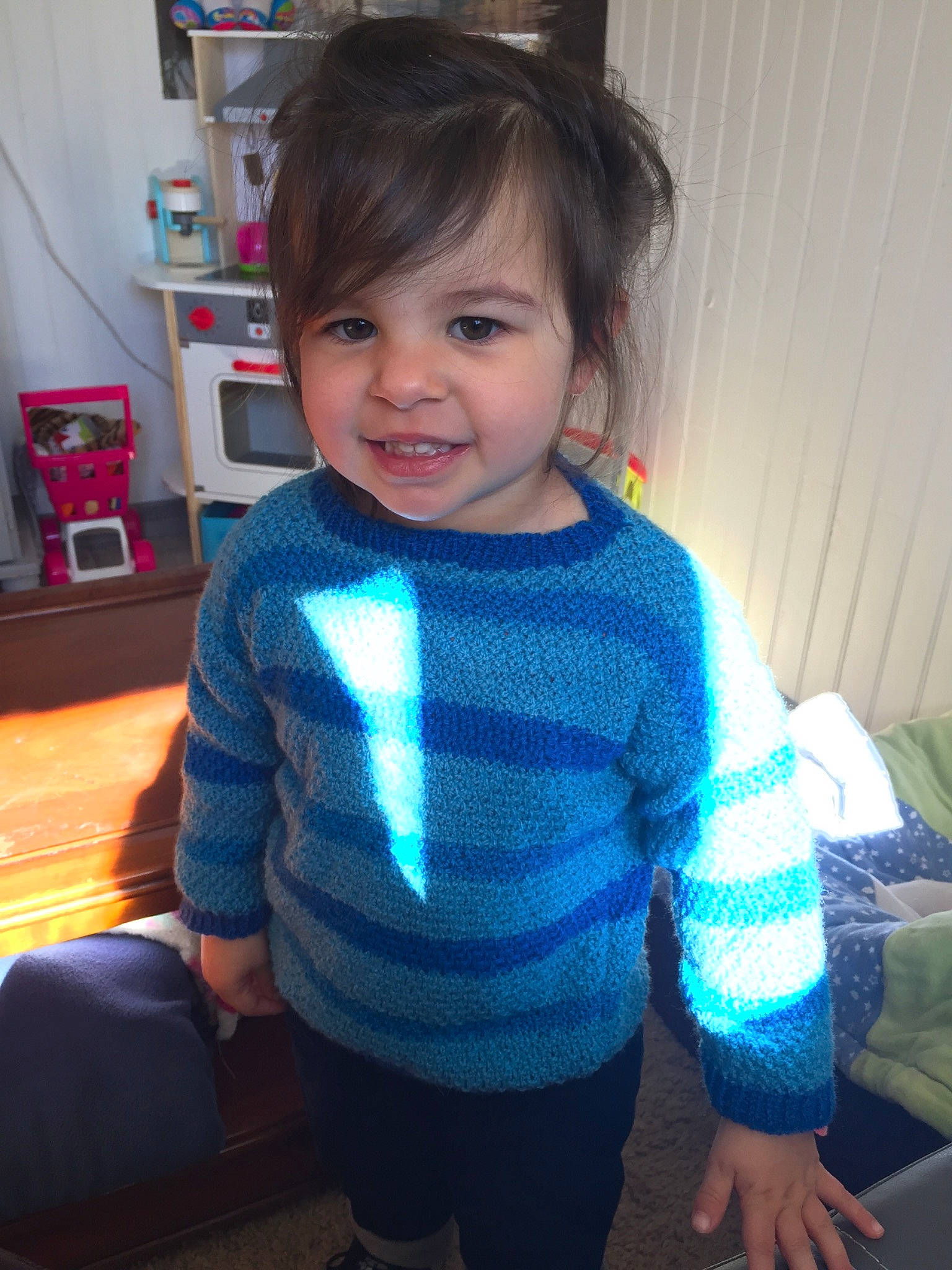 Asuna participe au concours pour gagner de l'argent avec cette photo : arm, baby, cheek, child, electronic_device, face, hair, hairstyle, head, joy, knitting, neck, outerwear, person, skin, sleeve, smile, standing, sweater, t_shirt