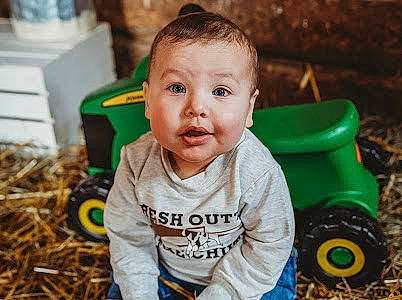 Bentley joined the competition — help win amazing prizes! automotive_tire, baby, child, fun, garden, grass, happy, leisure, mammal, people_in_nature, person, plant, recreation, riding_toy, sitting, soil, tire, toddler, tree, wheel