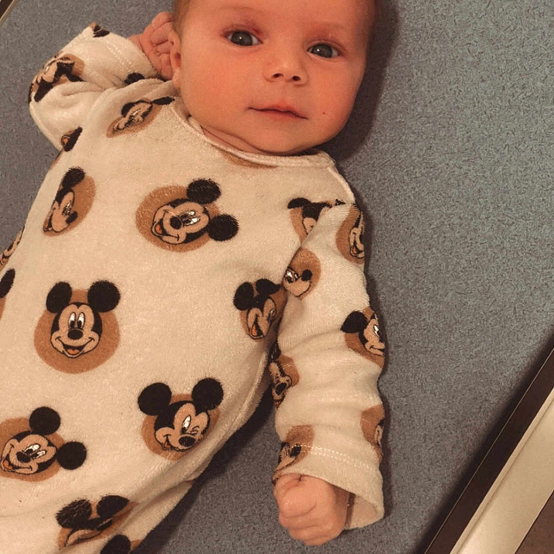 Daiana a rejoint le concours — aidez-le/la à gagner de superbes lots ! baby, baby_boy, baby_fashion, baby_garment, baby_girl, child, clothing, cute, cute_outfit, face, indoor, infant, lying_down, mickey_mouse, newborn, onesie, person, portrait, smile, soft_texture