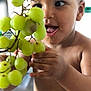 Alloux Nhesta a rejoint le concours — aidez-le/la à gagner de superbes lots ! baby, child, closeup, curious, eyes, face, food, fruit, grapes, hand, happy, healthy, indoor, mouth, natural_light, person, skin, smile, toddler, tongue