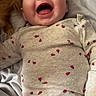 baby, infant, smiling, laughing, onesie, ladybug_pattern, bed, blanket, soft, clothing, person, cute, happy, joyful, child, skin, head, face, indoors, lying