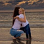 Karter joined the competition — help win amazing prizes! child, woman, hugging, beach, ocean, water, sunset, clouds, barefoot, long_hair, blonde_hair, jeans, white_shirt, crouching, sand, reflection, sky, casual_clothing, shore, happy