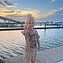Karter joined the competition — help win amazing prizes! black_shoes, blond_hair, boats, bridge, casual_clothing, child, dock, evening, happy, nature, outdoor, person, pier, shorts, sky, smiling, sunset, tshirt, water, waving