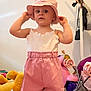 Valentine participe au concours pour gagner de l'argent avec cette photo : toddler, child, pink_hat, pink_shorts, white_top, toy, stuffed_animal, indoor, playroom, childrens_toy, stroller, floor, person, clothing, face, headwear, cute, standing, young_child, playful