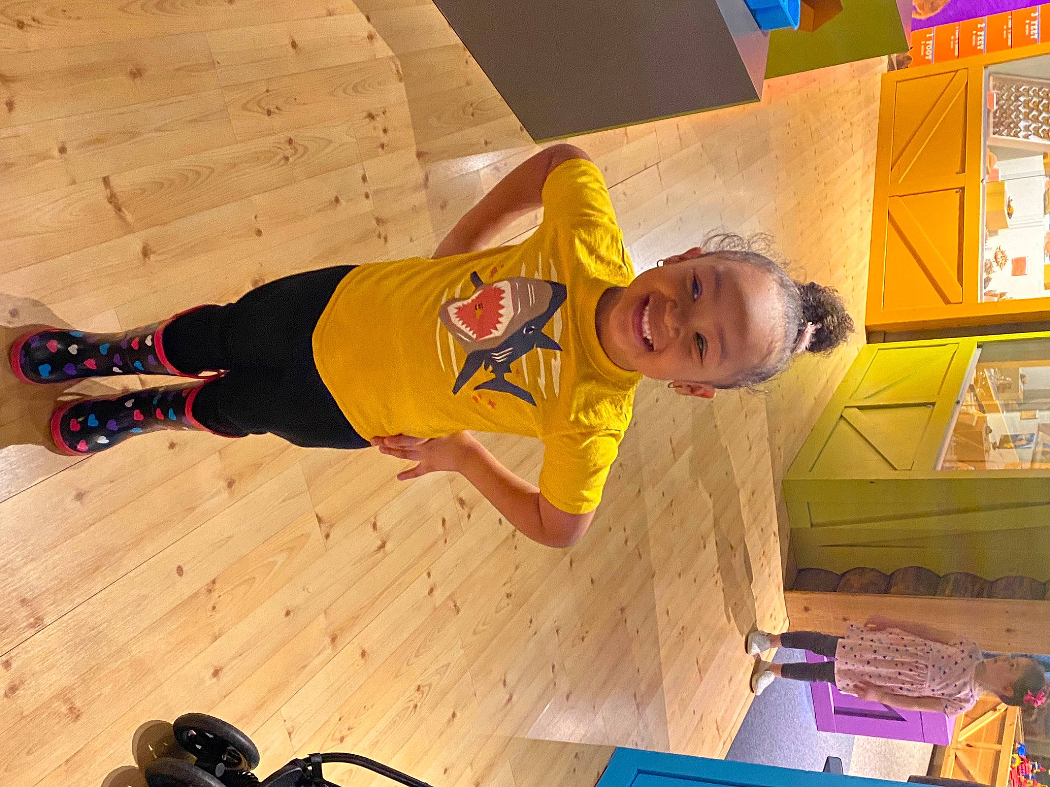 Legaci Caress is registered to the contest to win money with this photo: audio_equipment, flooring, fun, happy, hardwood, headphones, joy, leisure, logo, orange, person, room, smile, sportswear, t_shirt, tire, toddler, wood, wood_flooring, world