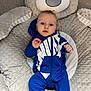 baby, bear, blue_onesie, carpet, child, clothing, comfort, cute, expression, eyes, face, hoodie, indoor, infant, nike, person, plush_toy, sitting, soft_texture, young_child