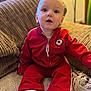Owen joined the competition — help win amazing prizes! baby, child, red_tracksuit, socks, couch, indoor, person, seated, face, expression, comfortable, cozy, textile, furniture, home, cute, portrait, young, sitting, colorful