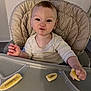 baby, banana, casual, child, clothing, cushion, cute, expression, food, funny_face, hand, high_chair, indoor, mealtime, person, portrait, seat, striped, tray, young_child