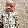 baby, smiling, infant, onesie, leopard_print, soft_texture, carpet, lying_down, cute, child, happy, face, head, skin, clothing, indoors, portrait, person, comfortable, young