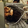 Ginger joined the competition — help win amazing prizes! cat, orange_cat, black_cat, basket, plastic_chair, floor, cat_food, bowl, indoor, pet, sleeping, furry, cozy, feline, resting, wire_basket, stacked_items, household, domestic, companion