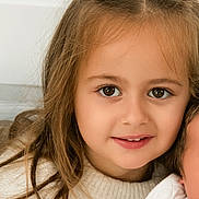 Joy participe au concours pour gagner de l'argent avec cette photo : child, girl, portrait, smile, face, brown_eyes, long_hair, sweater, cozy, indoor, closeup, cute, young, happy, person, casual, natural_light, childhood, innocence, warm