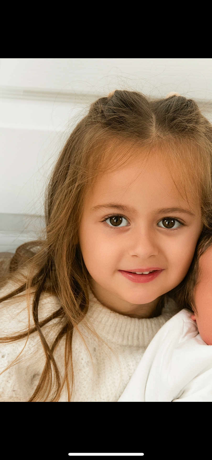 Joy participe au concours pour gagner de l'argent avec cette photo : child, girl, portrait, smile, face, brown_eyes, long_hair, sweater, cozy, indoor, closeup, cute, young, happy, person, casual, natural_light, childhood, innocence, warm