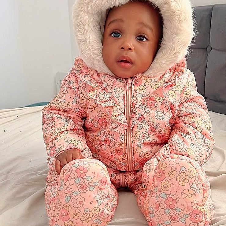 Aliza is registered to the contest to win money with this photo: baby, blanket, bonnet, cap, clothing, coat, face, happy, hat, head, hood, hoodie, jacket, knitwear, person, photography, portrait, sitting, sweater, sweatshirt