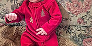 Jordan joined the competition — help win amazing prizes! baby, infant, red_clothing, hat, onesie, couch, blanket, floral_pattern, indoor, portrait, child, cute, cozy, smile, face, person, seated, warm, home, holiday_theme